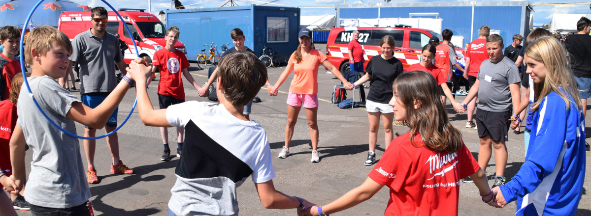 Palokuntanuoria leikkimässä aikuisen ohjauksella palokuntanuorten leirillä